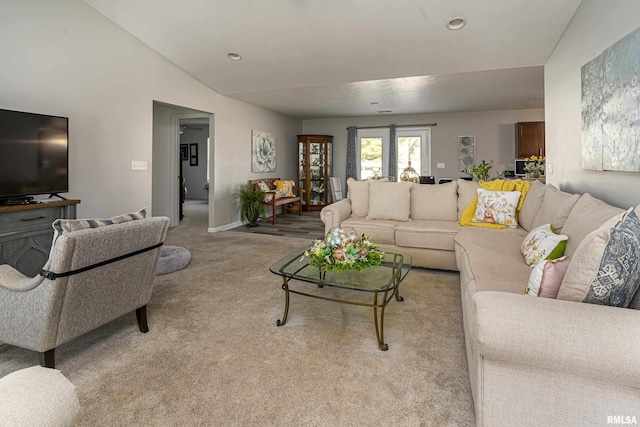 living room featuring baseboards, light carpet, and vaulted ceiling