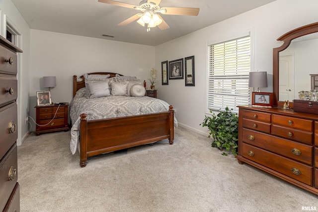 bedroom featuring light carpet, visible vents, baseboards, and ceiling fan