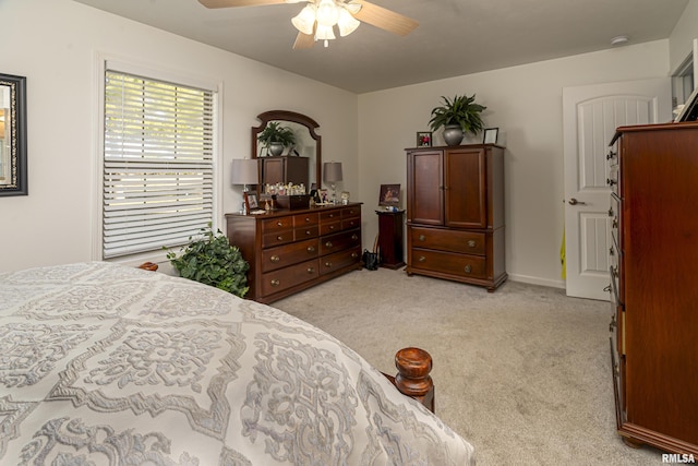 bedroom featuring light colored carpet, baseboards, and ceiling fan