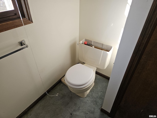 bathroom featuring toilet and baseboards