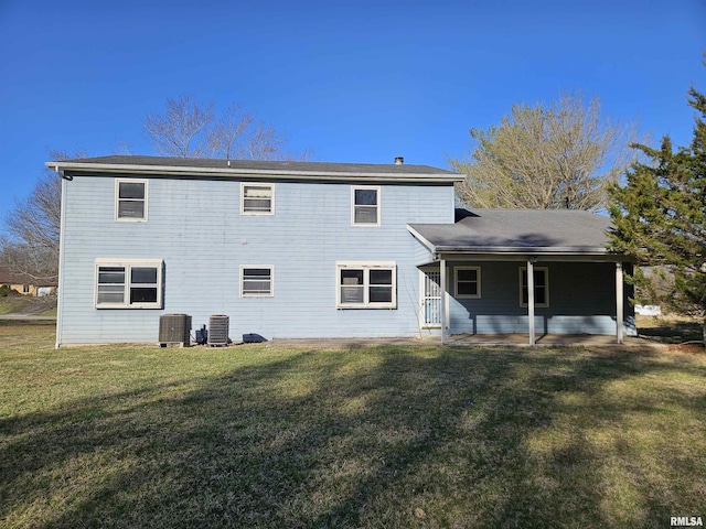 rear view of property featuring cooling unit and a yard