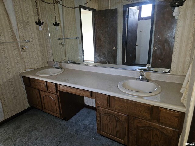 bathroom featuring a sink, double vanity, and wallpapered walls