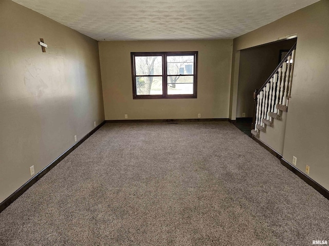 unfurnished room featuring stairs, carpet flooring, baseboards, and a textured ceiling