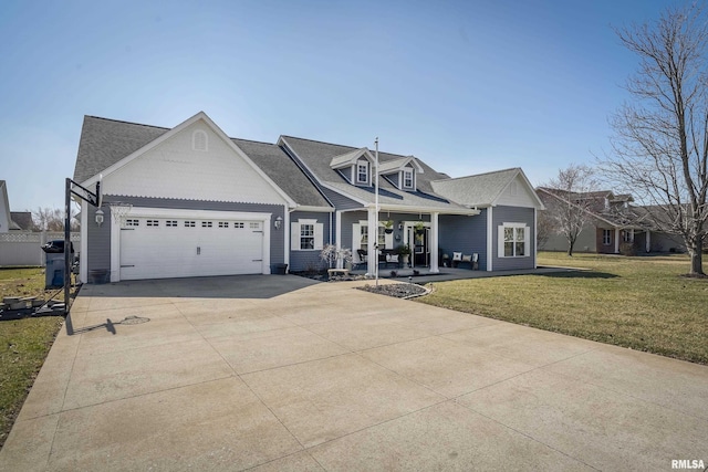 view of front facade featuring a front lawn, a porch, roof with shingles, a garage, and driveway