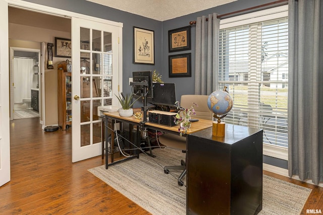 office area with wood finished floors, french doors, baseboards, and a textured ceiling