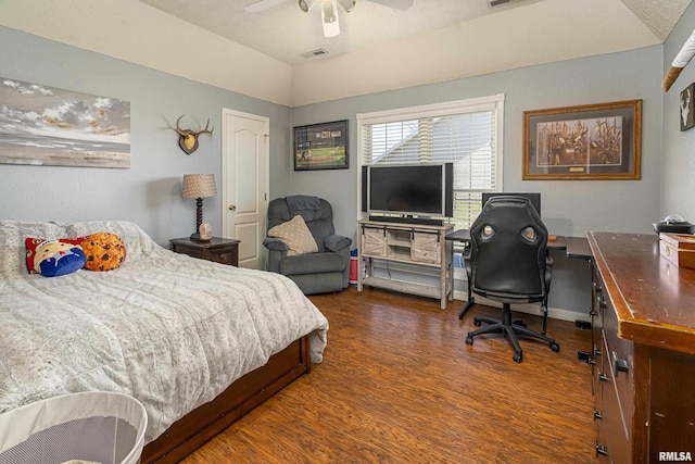 bedroom featuring a ceiling fan, wood finished floors, visible vents, baseboards, and vaulted ceiling