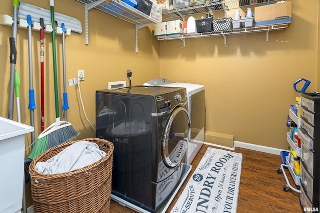 clothes washing area featuring laundry area, independent washer and dryer, baseboards, and wood finished floors