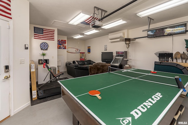 game room with a garage, attic access, finished concrete flooring, and a wall mounted AC