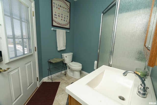 bathroom with baseboards, a shower with door, and a sink