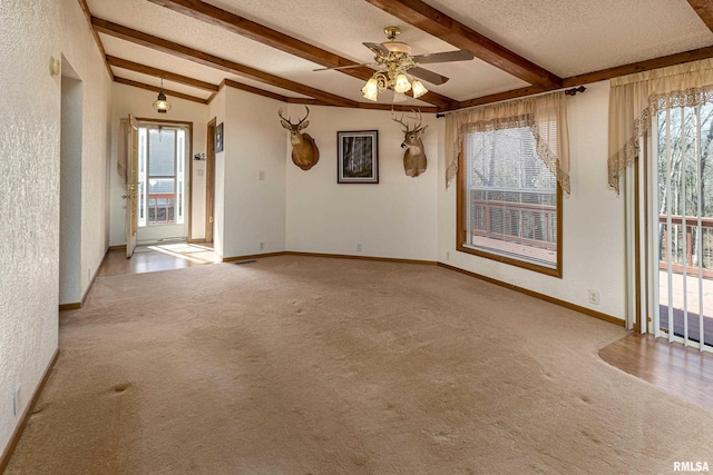 spare room with carpet flooring, a healthy amount of sunlight, a textured ceiling, and baseboards