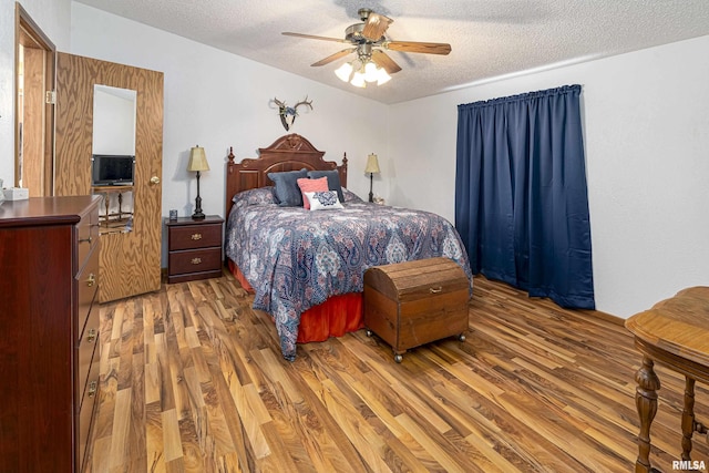 bedroom featuring light wood-style floors, ceiling fan, and a textured ceiling