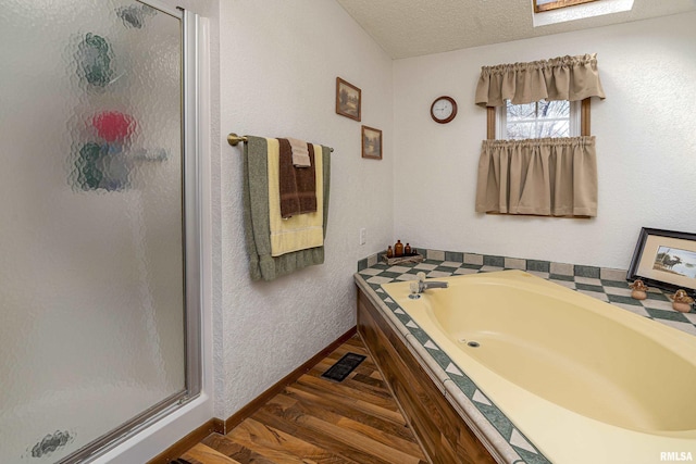 bathroom featuring visible vents, a garden tub, a stall shower, a textured ceiling, and wood finished floors