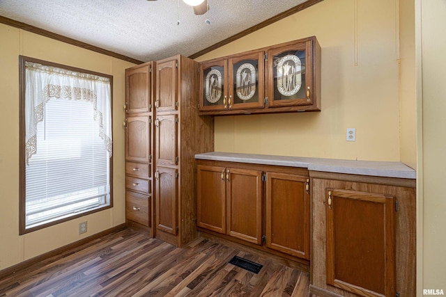 kitchen featuring brown cabinets, a textured ceiling, light countertops, and vaulted ceiling