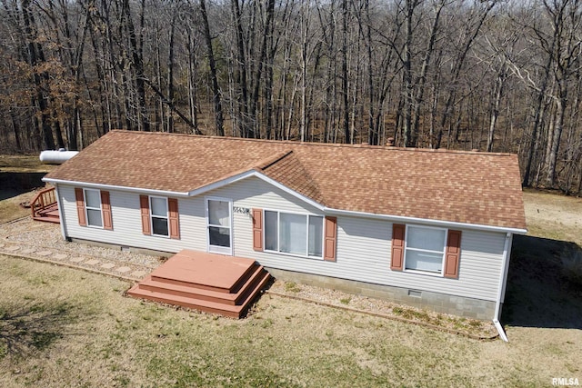 view of front of home with crawl space, a forest view, a front lawn, and a shingled roof