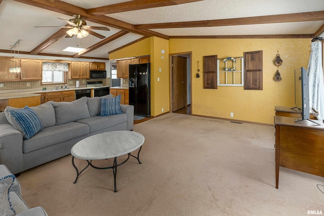 living room with vaulted ceiling with beams, light colored carpet, visible vents, and baseboards