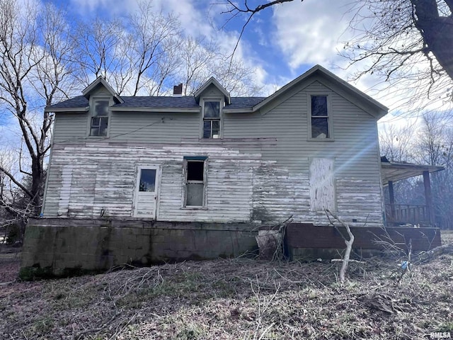 rear view of property featuring a chimney