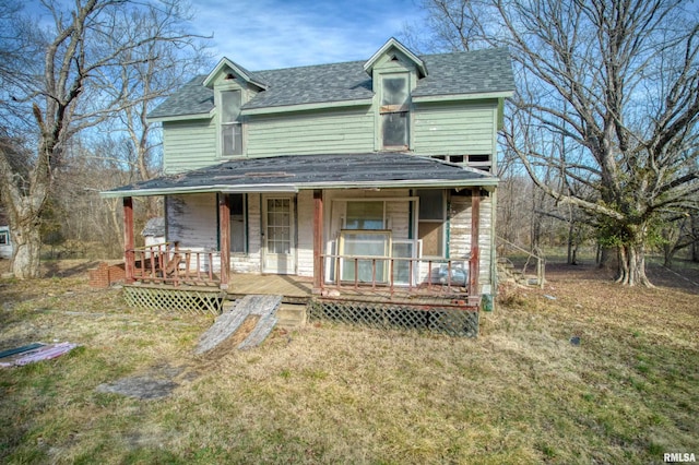 view of front facade featuring roof with shingles, a porch, and a front yard