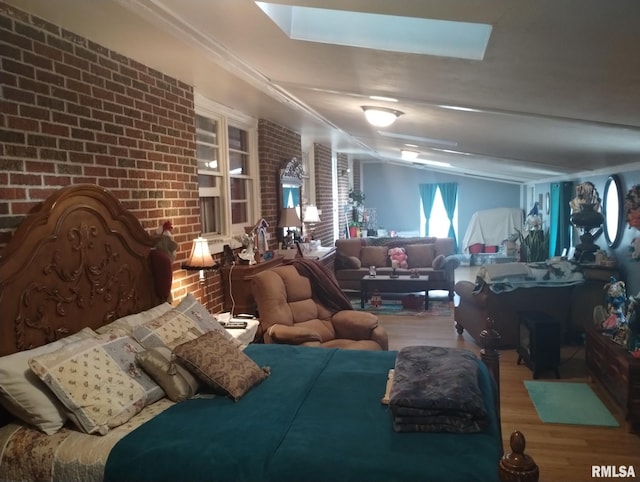 bedroom featuring wood finished floors and brick wall