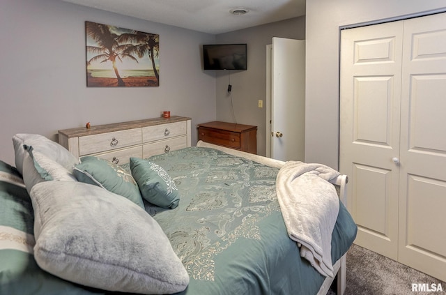 bedroom with a closet, visible vents, and carpet