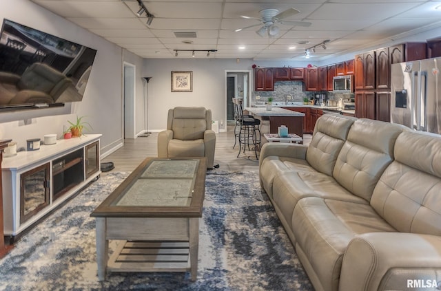 living area featuring visible vents, wood finished floors, rail lighting, baseboards, and ceiling fan