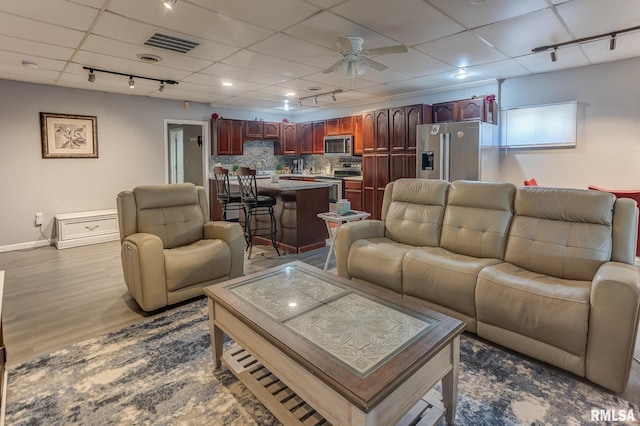 living area featuring a ceiling fan, visible vents, dark wood-style flooring, a drop ceiling, and rail lighting