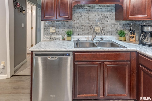 kitchen featuring a sink, tasteful backsplash, dishwasher, and light countertops