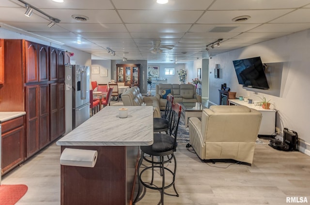 kitchen with high end refrigerator, visible vents, a breakfast bar area, and open floor plan