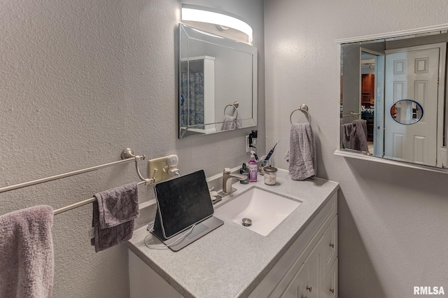 bathroom with vanity and a textured wall