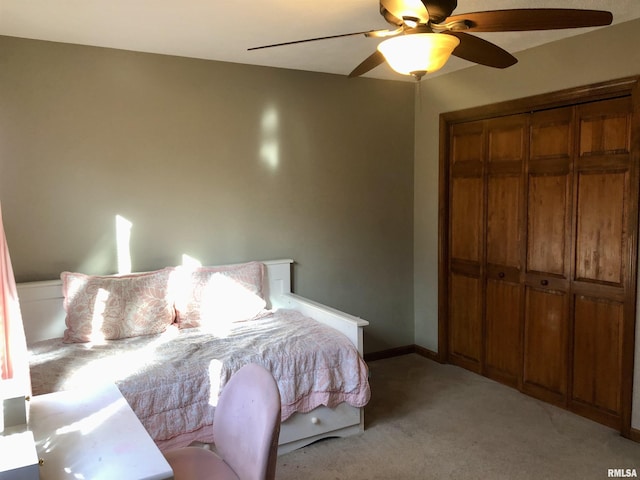 bedroom featuring a closet, light carpet, baseboards, and a ceiling fan