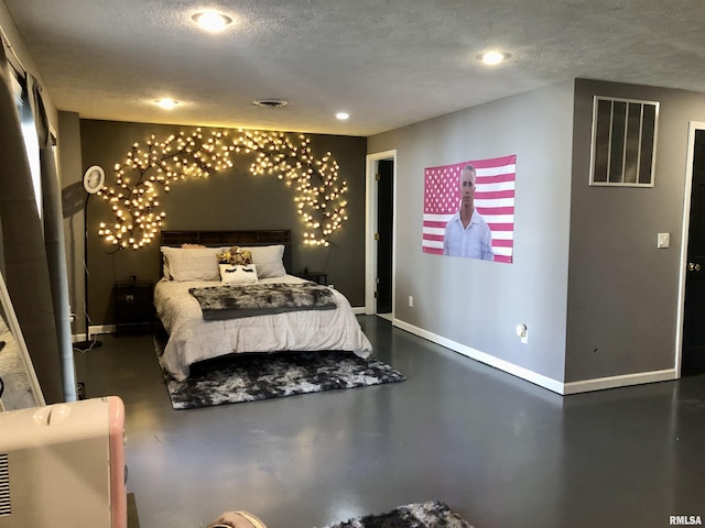 bedroom with visible vents, baseboards, a textured ceiling, and finished concrete flooring