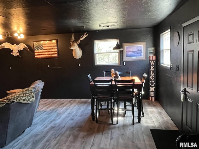 dining area with a textured ceiling and wood finished floors