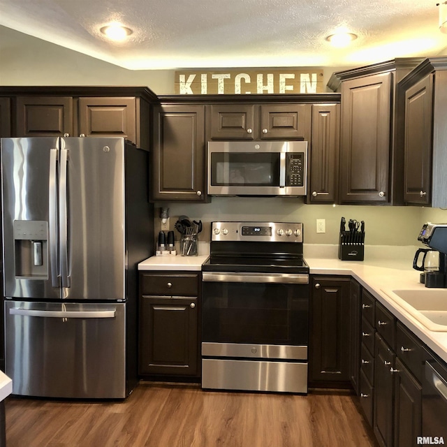 kitchen featuring dark wood finished floors, stainless steel appliances, and light countertops