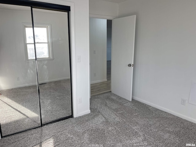 unfurnished bedroom featuring a closet, carpet flooring, and baseboards