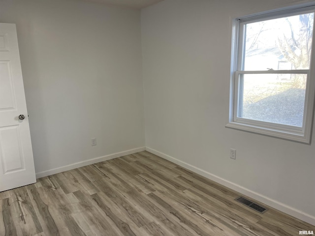 empty room with visible vents, baseboards, and wood finished floors