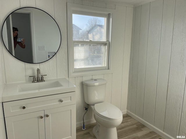 bathroom featuring toilet, wood finished floors, and a wealth of natural light