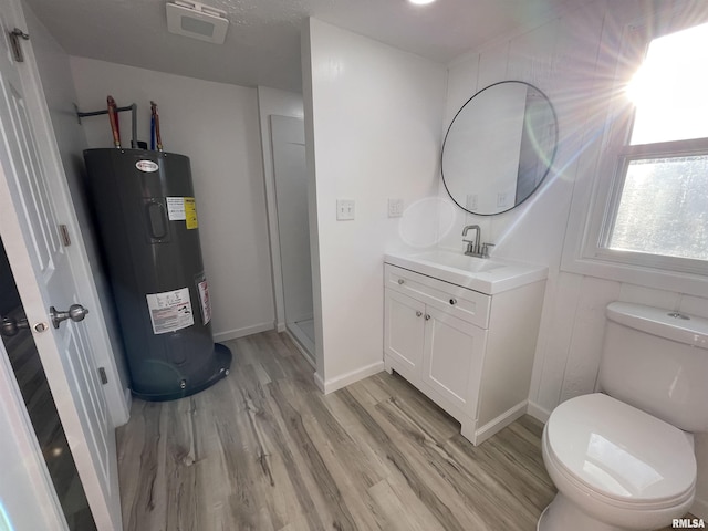 bathroom featuring vanity, wood finished floors, visible vents, water heater, and toilet