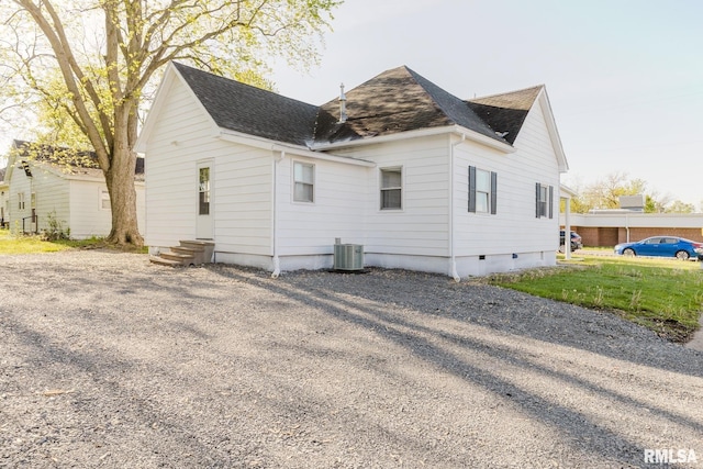 back of property with central air condition unit and a shingled roof