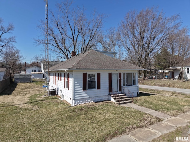 bungalow-style house with a shingled roof, entry steps, a front yard, central AC unit, and a chimney