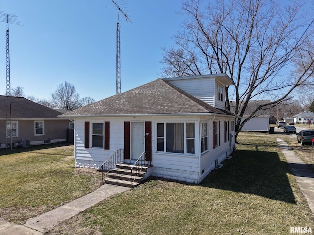 bungalow-style home featuring cooling unit, roof with shingles, a front lawn, and entry steps