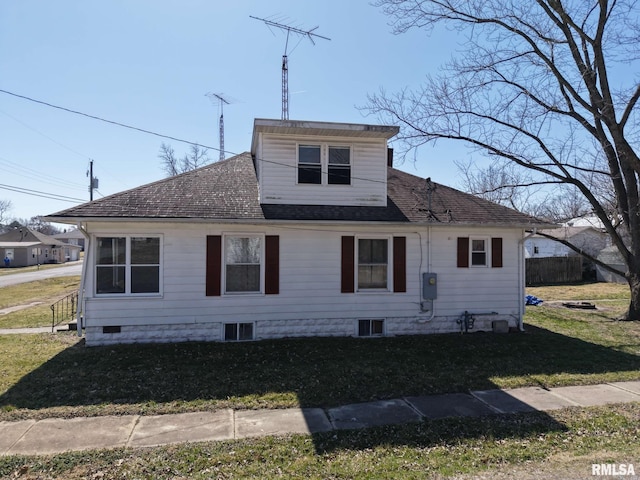 view of front facade with fence, a front yard, and roof with shingles