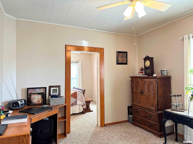 office space with light colored carpet, crown molding, baseboards, and ceiling fan