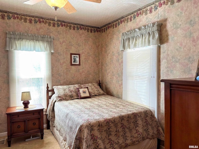 bedroom featuring light colored carpet and a ceiling fan