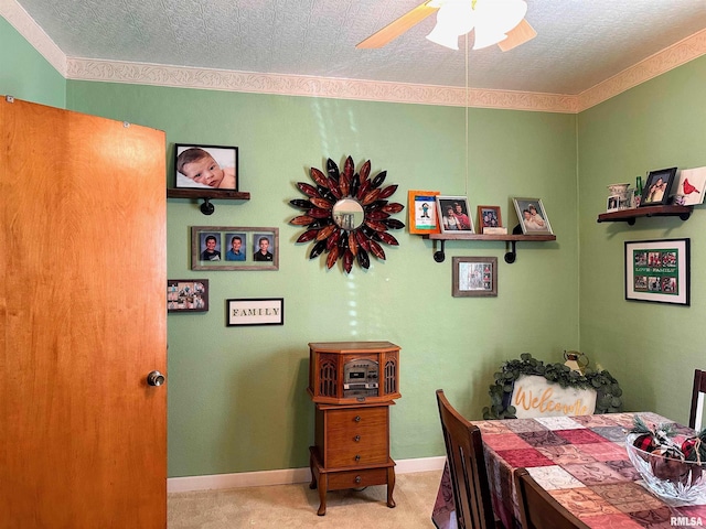 carpeted dining space with baseboards, a textured ceiling, and a ceiling fan