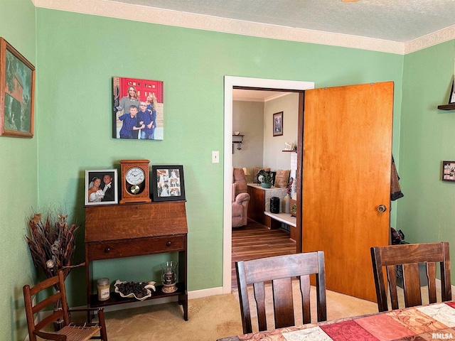 dining room featuring a textured ceiling, crown molding, and carpet floors