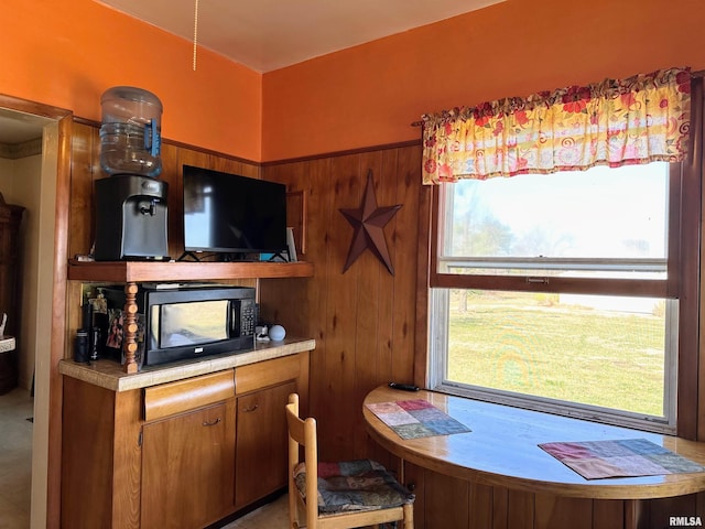 kitchen with brown cabinetry, light countertops, and black microwave