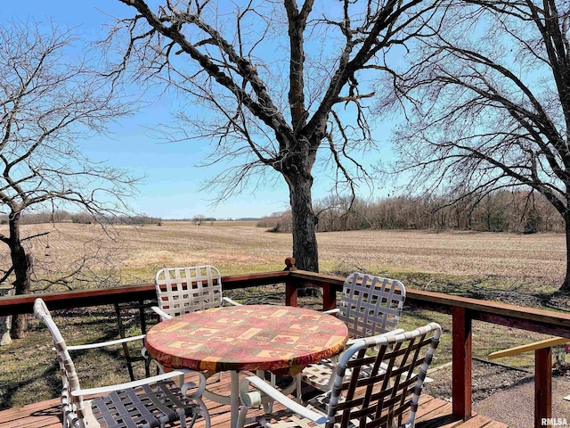 deck with a rural view and outdoor dining space