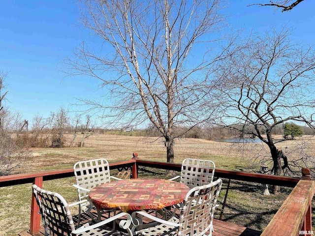 wooden terrace with a lawn and outdoor dining area