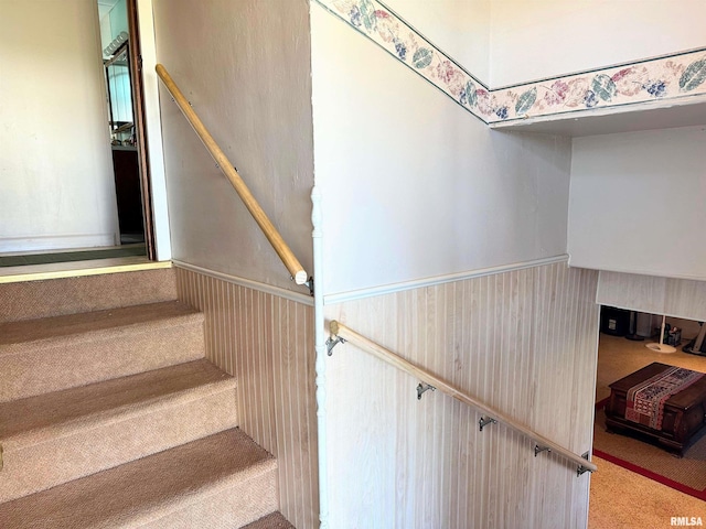 stairway with carpet flooring and wainscoting