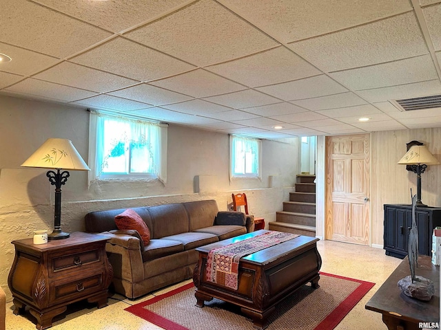 living room featuring visible vents, stairway, and a paneled ceiling