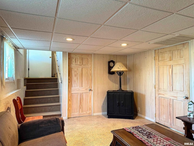 living area featuring visible vents, recessed lighting, wood walls, baseboards, and stairs